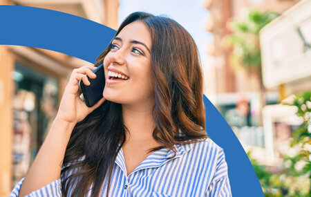 Young hispanic woman smiling and happy while talking on a smartphone 